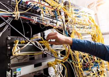 Sunucu odasında çalışan ağ mühendisi. Ağ kabloları anahtarlara bağlanıyor