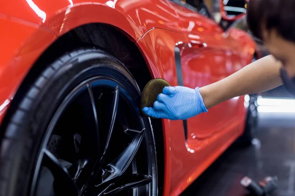 Trabajador de servicio de coche puliendo ruedas de coche con tela de microfibra. — Foto de Stock
