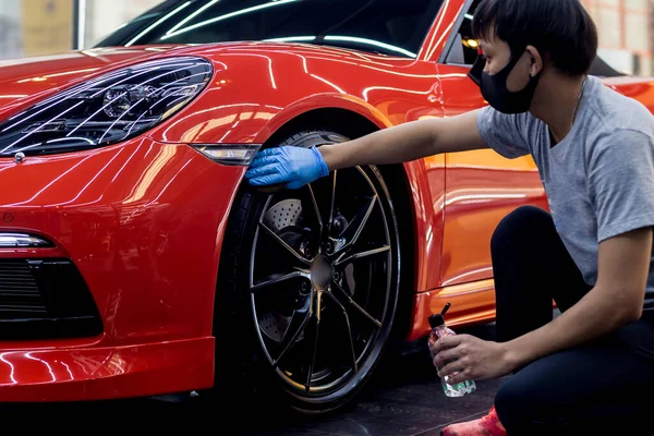 Carro serviço trabalhador polimento carro rodas com pano de microfibra. — Fotografia de Stock