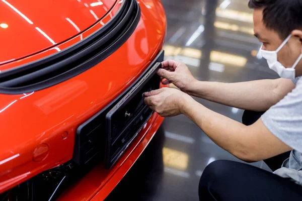 Technician changing car plate number in service center. — Stock Photo, Image