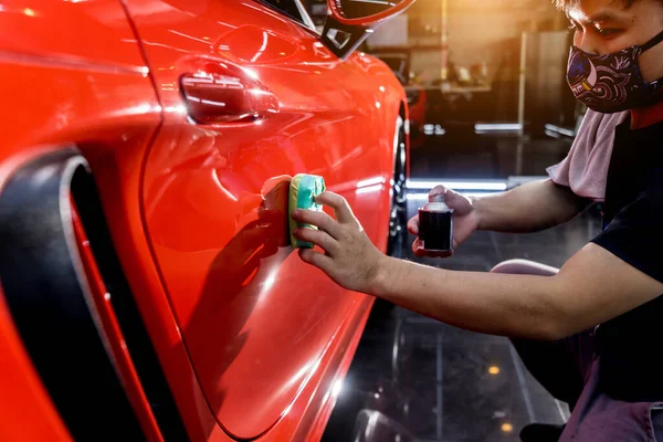 Trabajador de servicio de coches aplicando nano recubrimiento en un detalle del coche — Foto de Stock