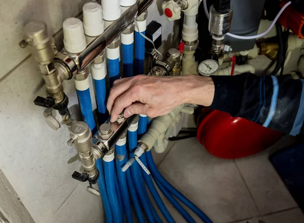 Heating engineer fixing modern heating system in boiler room.