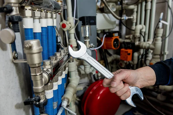 Heating engineer installing modern heating system in boiler room.