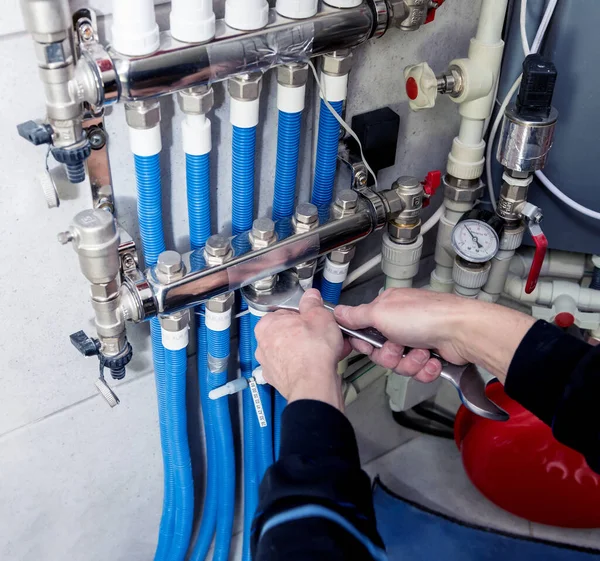 Heating engineer installing modern heating system in boiler room.