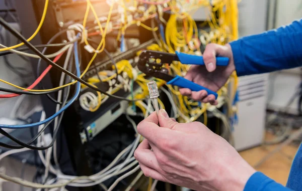 Síťový inženýr pracující v serverovně. Připojování síťových kabelů k přepínačům — Stock fotografie