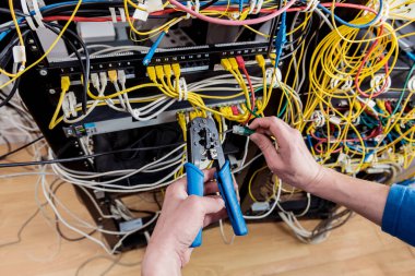 Sunucu odasında çalışan ağ mühendisi. Ağ kabloları anahtarlara bağlanıyor