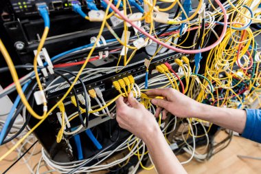 Sunucu odasında çalışan ağ mühendisi. Ağ kabloları anahtarlara bağlanıyor