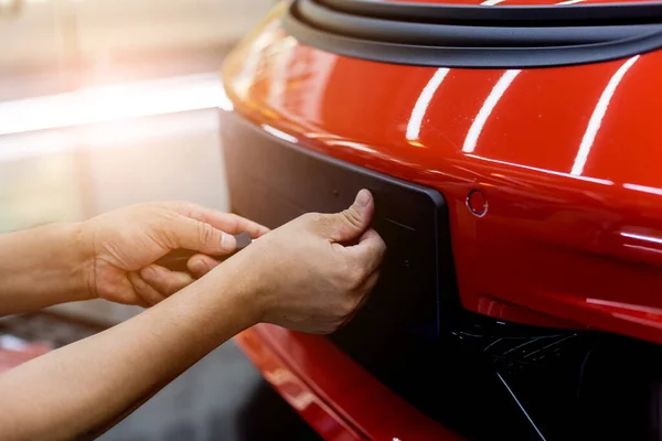 Tecnico che cambia il numero di targa dell'auto nel centro assistenza . — Foto Stock