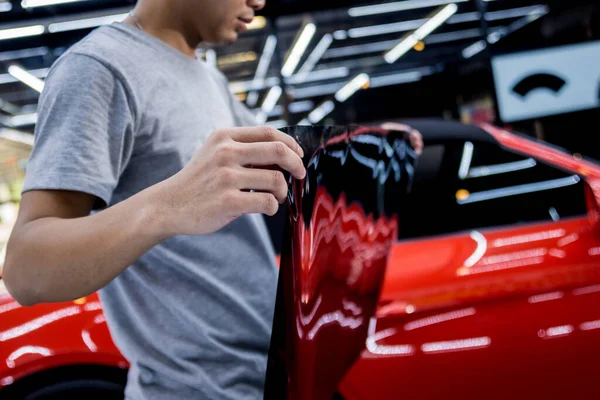 Applying tinting foil on a car window in a auto service — Stock Photo, Image