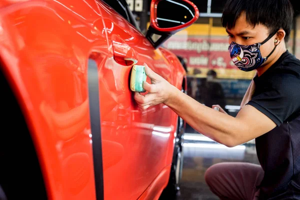 Trabajador de servicio de coches aplicando nano recubrimiento en un detalle del coche — Foto de Stock