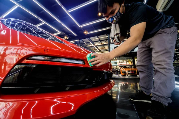 Lavoratore di servizio di automobile che applica il rivestimento nano su un dettaglio di automobile — Foto Stock