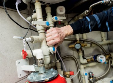 Isıtma mühendisi kazan dairesinde modern ısıtma sistemini tamir ediyor.. 