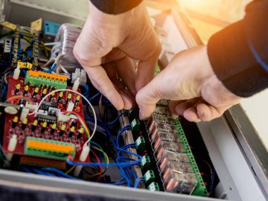 Adam elektrik santralini otomatik şalterlerle onarıyor..