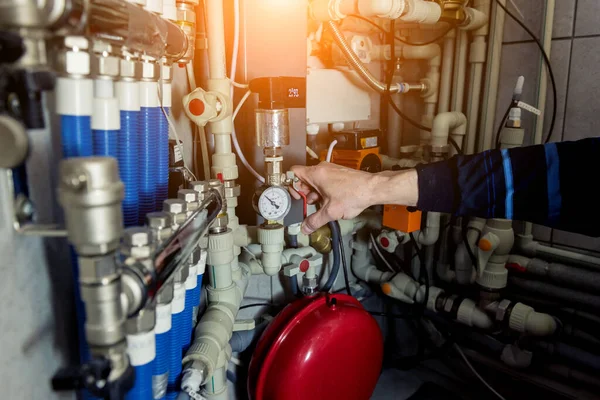 Heating engineer fixing modern heating system in boiler room. — Stock Photo, Image