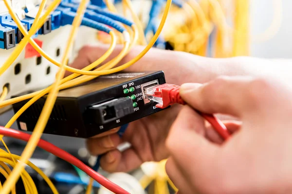 Ingeniero de redes trabajando en la sala de servidores. Conexión de cables de red a interruptores — Foto de Stock