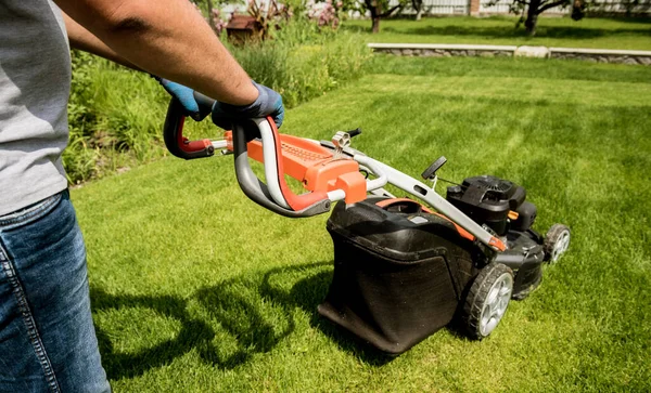 Gardener mowing the lawn. Landscape design. Green background