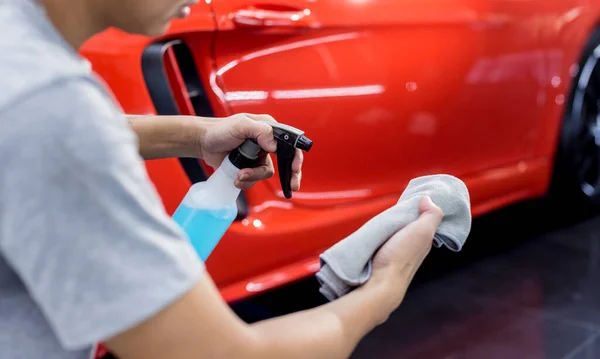 Autoservice-Mitarbeiter poliert Autoräder mit Mikrofasertuch. — Stockfoto