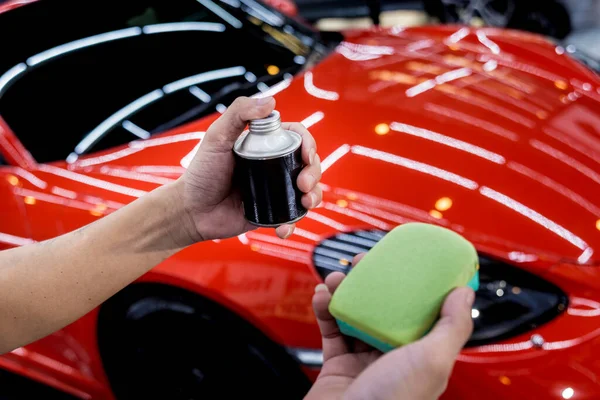 Trabajador de servicio de coches aplicando nano recubrimiento en un detalle del coche —  Fotos de Stock