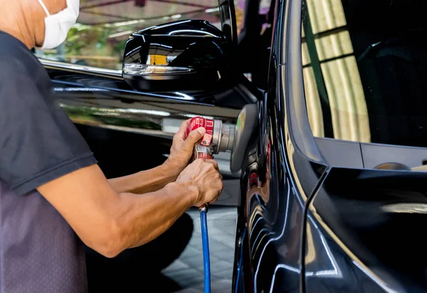 Arbetaren polerar en bil med det elektriska verktyget. — Stockfoto