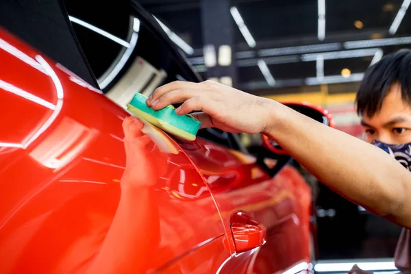 Trabalhador de serviço de carro aplicando revestimento nano em um detalhe do carro — Fotografia de Stock