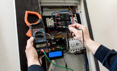 Adam elektrik santralini otomatik şalterlerle onarıyor..