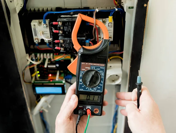 The man is repairing the switchboard voltage with automatic switches. — Stock Photo, Image