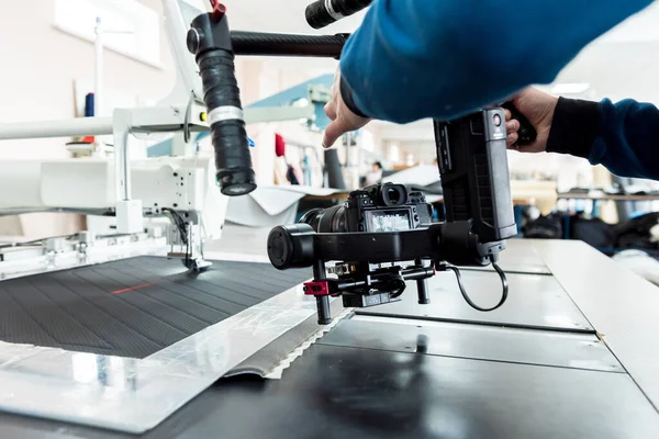 Videógrafo usando stadicam, haciendo video de la máquina en la fábrica de coser — Foto de Stock