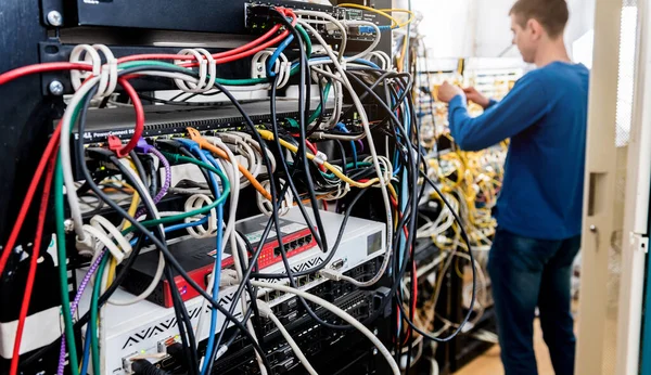 Síťový inženýr pracující v serverovně. Připojování síťových kabelů k přepínačům — Stock fotografie