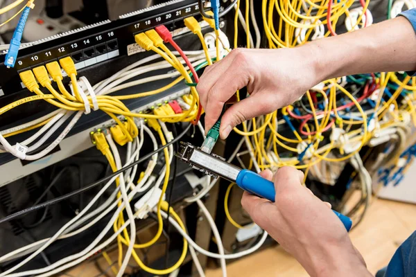 Netwerktechnicus werkt in de serverruimte. Netwerkkabels aansluiten op schakelaars — Stockfoto