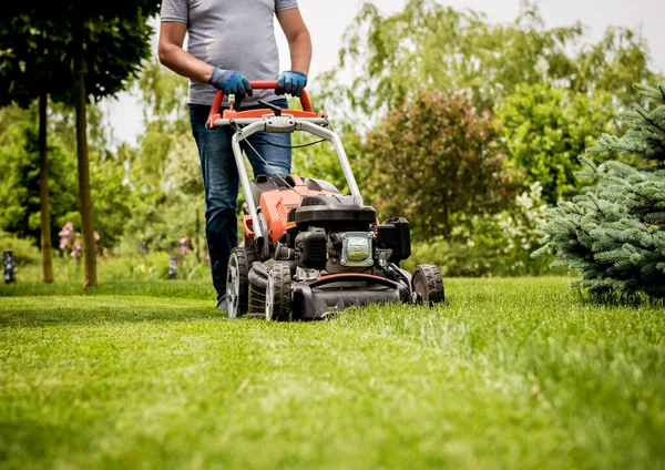 Gardener mowing the lawn. Landscape design. Green grass background — Stock Photo, Image