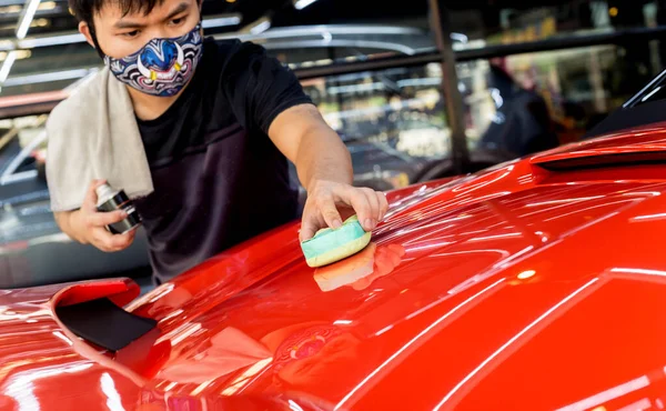 Trabajador de servicio de coches aplicando nano recubrimiento en un detalle del coche —  Fotos de Stock