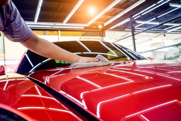 Autoservice-Mitarbeiter poliert Auto mit Mikrofasertuch. — Stockfoto