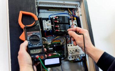Adam elektrik santralini otomatik şalterlerle onarıyor..
