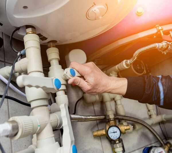 Инженер по отоплению устанавливает современную систему отопления в котельной
. 