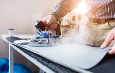 Tasarımcı koltuk kılıflarını diker. İnsan işi için demir kullanır..