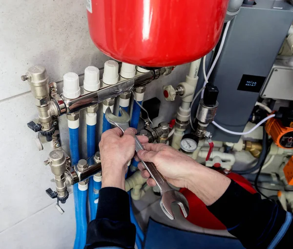 Heating engineer installing modern heating system in boiler room.