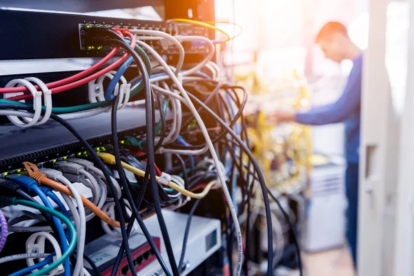 Ingeniero de redes trabajando en la sala de servidores. Conexión de cables de red a interruptores — Foto de Stock