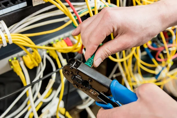 サーバールームで働くネットワークエンジニア。ネットワークケーブルをスイッチに接続する — ストック写真