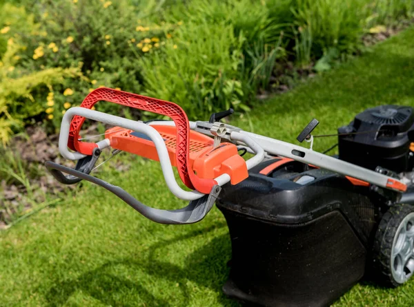 芝生に芝生の芝刈り機。夏の庭 — ストック写真