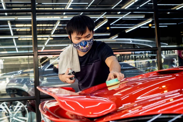 Trabajador de servicio de coches aplicando nano recubrimiento en un detalle del coche — Foto de Stock