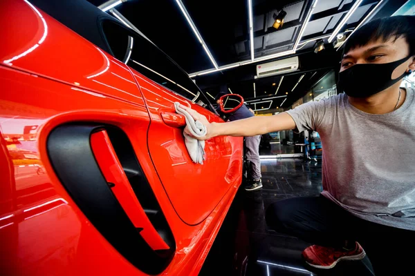 Trabajador de servicio de coche pulido coche con tela de microfibra. — Foto de Stock