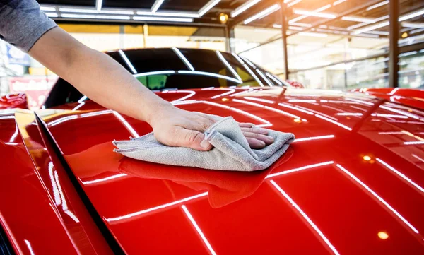 Autoservice-Mitarbeiter poliert Auto mit Mikrofasertuch. — Stockfoto
