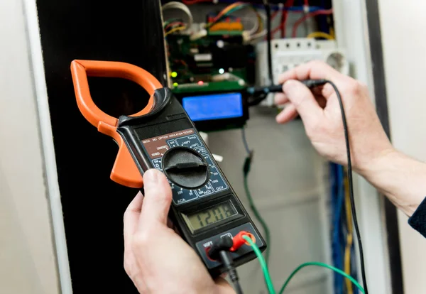 O homem está reparando a tensão do quadro com interruptores automáticos . — Fotografia de Stock