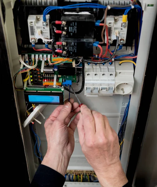 这个人正在用自动开关修理开关柜电压. — 图库照片