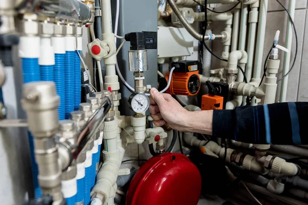 Heating engineer fixing modern heating system in boiler room. — Stock Photo, Image