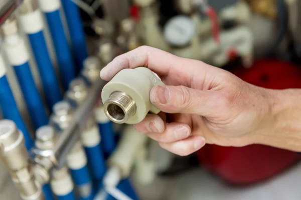 Heating engineer fixing modern heating system in boiler room.