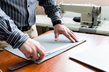 Tasarımcı koltuk kılıflarını diker. Adam işi için dikiş makinesi kullanıyor..