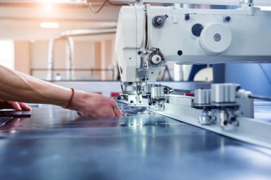 Kumaş endüstrisi üretim hattı. Tekstil fabrikası. Terzilik işlemi çalışıyor