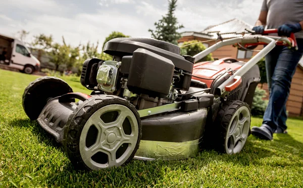 Gardener mowing the lawn. Landscape design. Green background