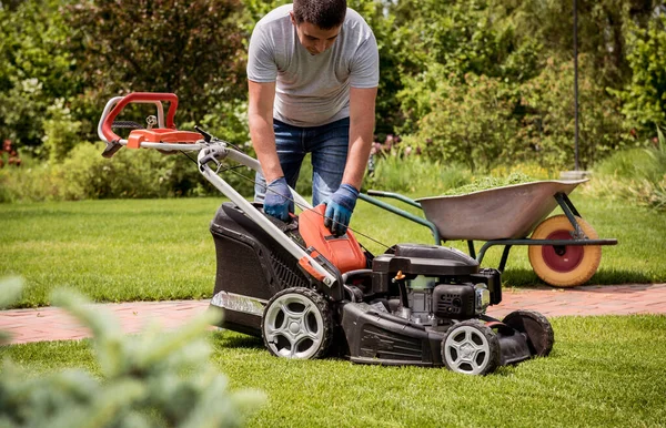 芝刈り機の芝刈り機の芝刈り機を刈った後に車列に空にする庭師. — ストック写真